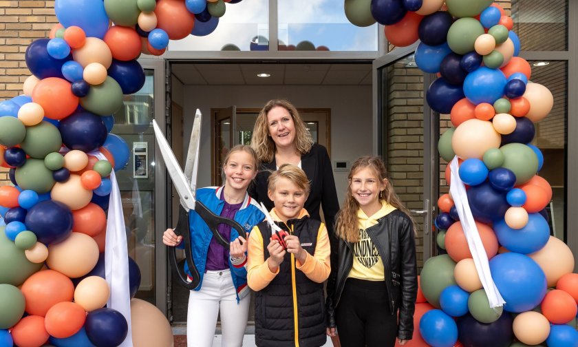 Balonnenboog met juf en drie kinderen voor opening gebouw Vroondaal